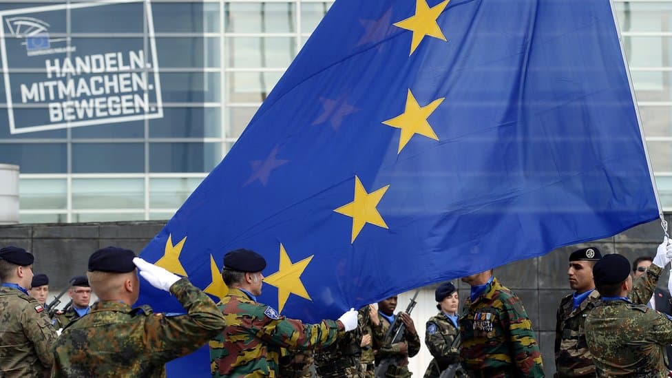 Військовослужбовці європейських країн з прапором ЄС. (джерело) [[https://militarnyi.com/uk/news/yes-vydilyt-ponad-1-mlrd-yevro-na-57-oboronnyh-proyektiv-sered-nyh-ukrayinski-kompaniyi/]]